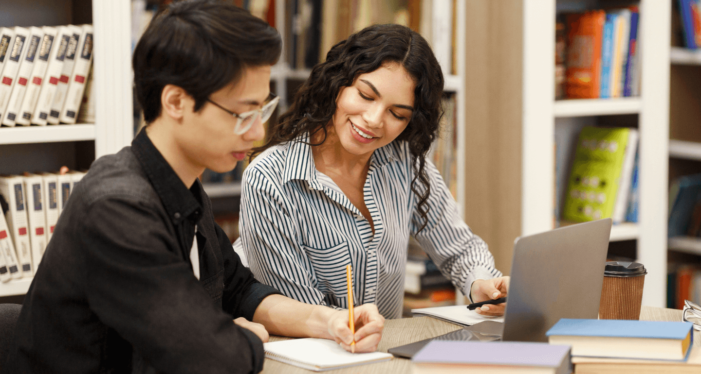 female student working with male student in library