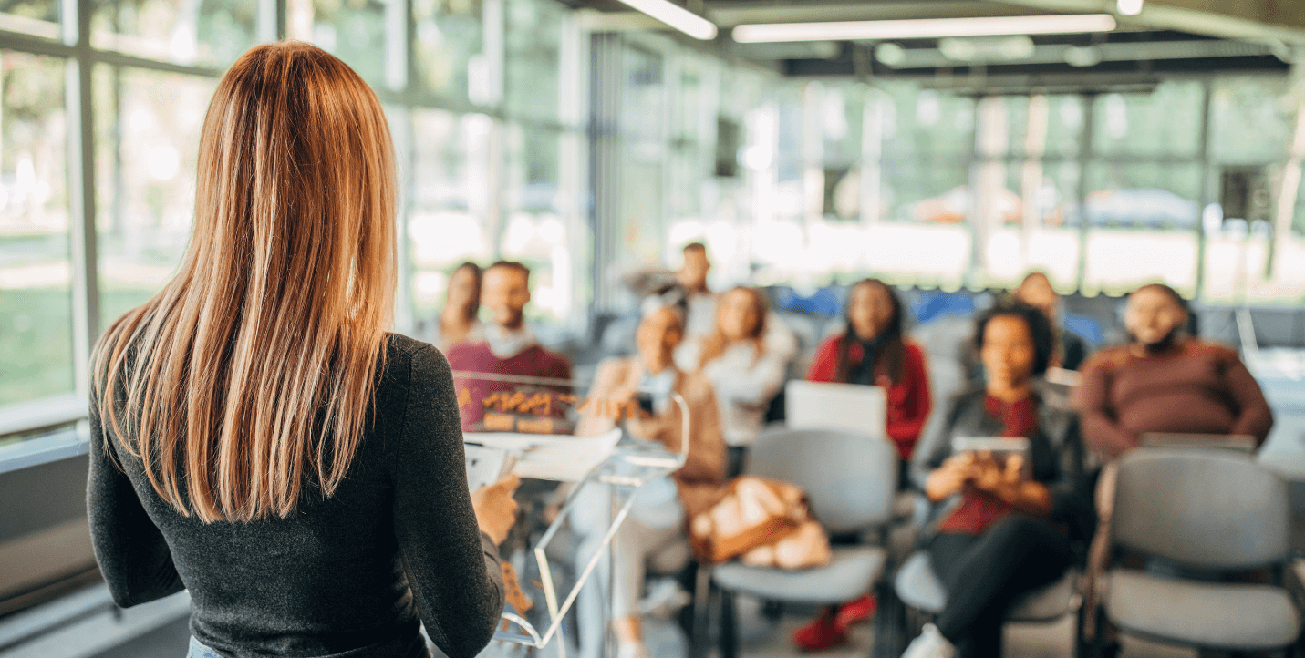 female presenting to a group of students - entrepreneurship