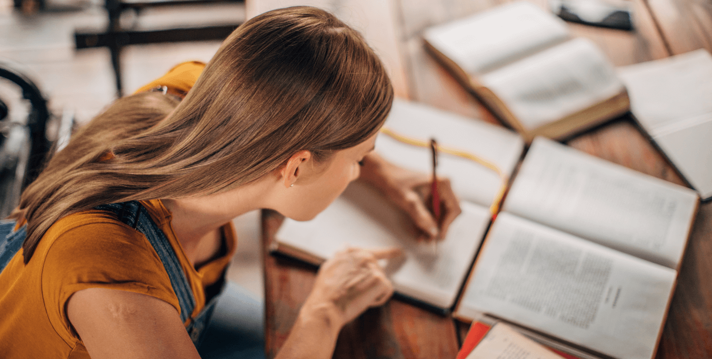 female student writing in notebook - sociology