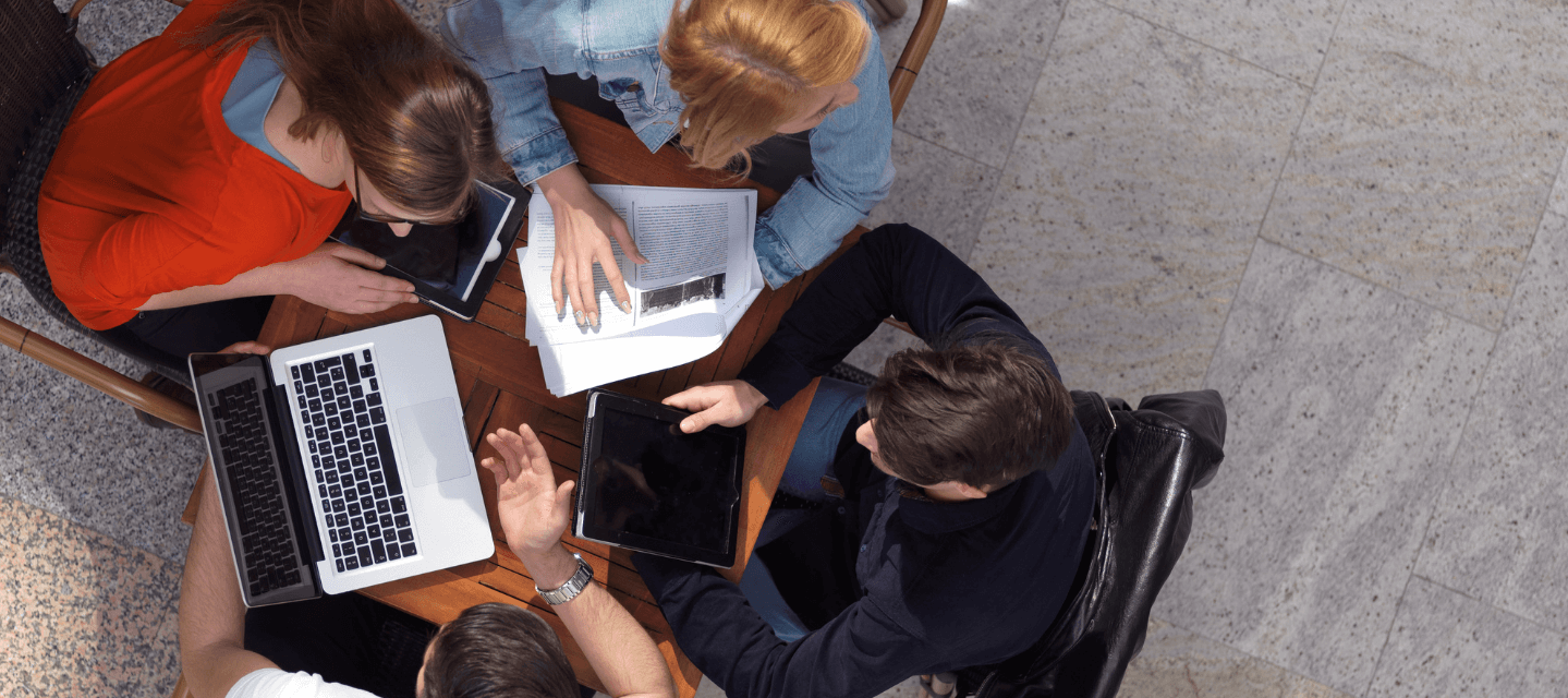 looking down on a group of students studying with computer and notes