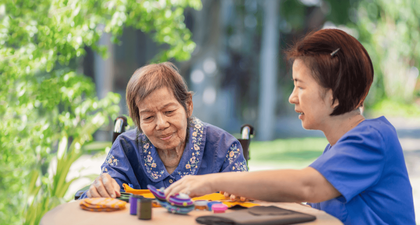 female student working with elderly woman for occupational therapy