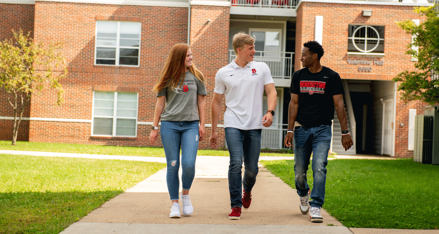 university housing available. three students walking away from their building talking