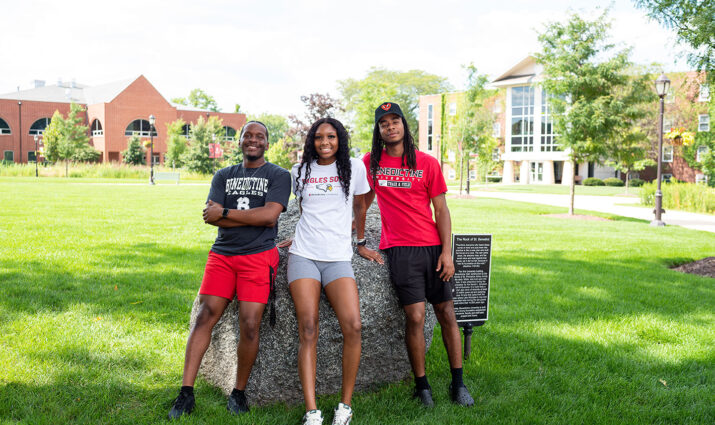 Ben Beginnings event, three students sitting on the Benedictine stone on the quad