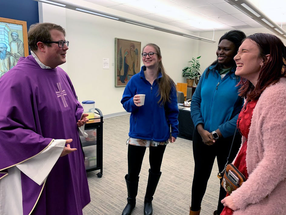 Students taking with priest